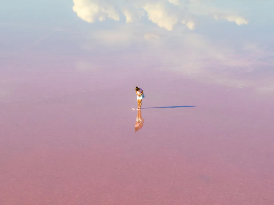 A woman standing on the pink surface of the Pink Lake at Dimboola, Victoria